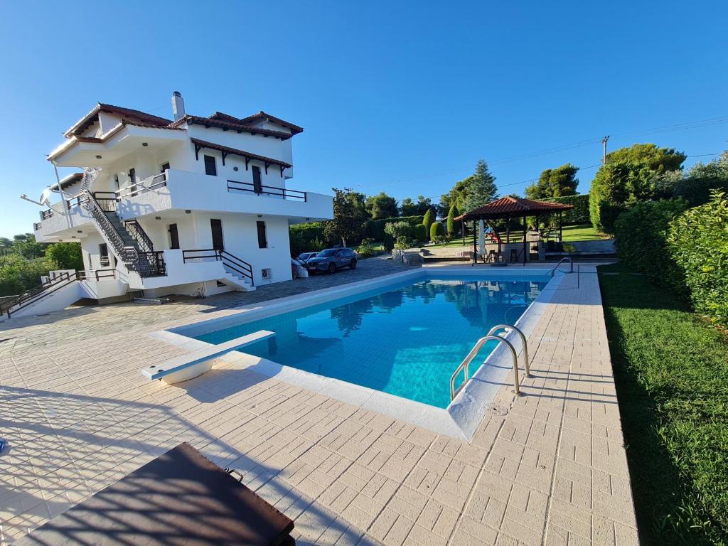 a house with a swimming pool next to a building at Villa ChrysPa Attica in Dhílesi