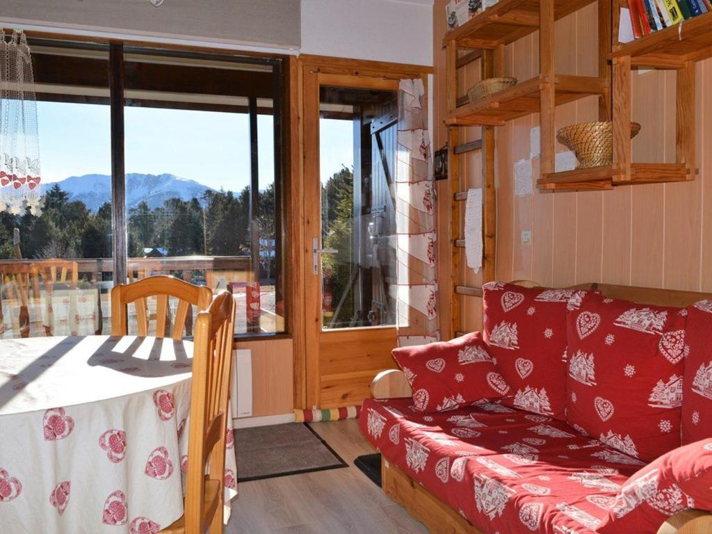 een woonkamer met een bank en een tafel bij Chalet Bolquère-Pyrénées 2000, 2 pièces, 4 personnes - FR-1-592-23 in Bolquere Pyrenees 2000