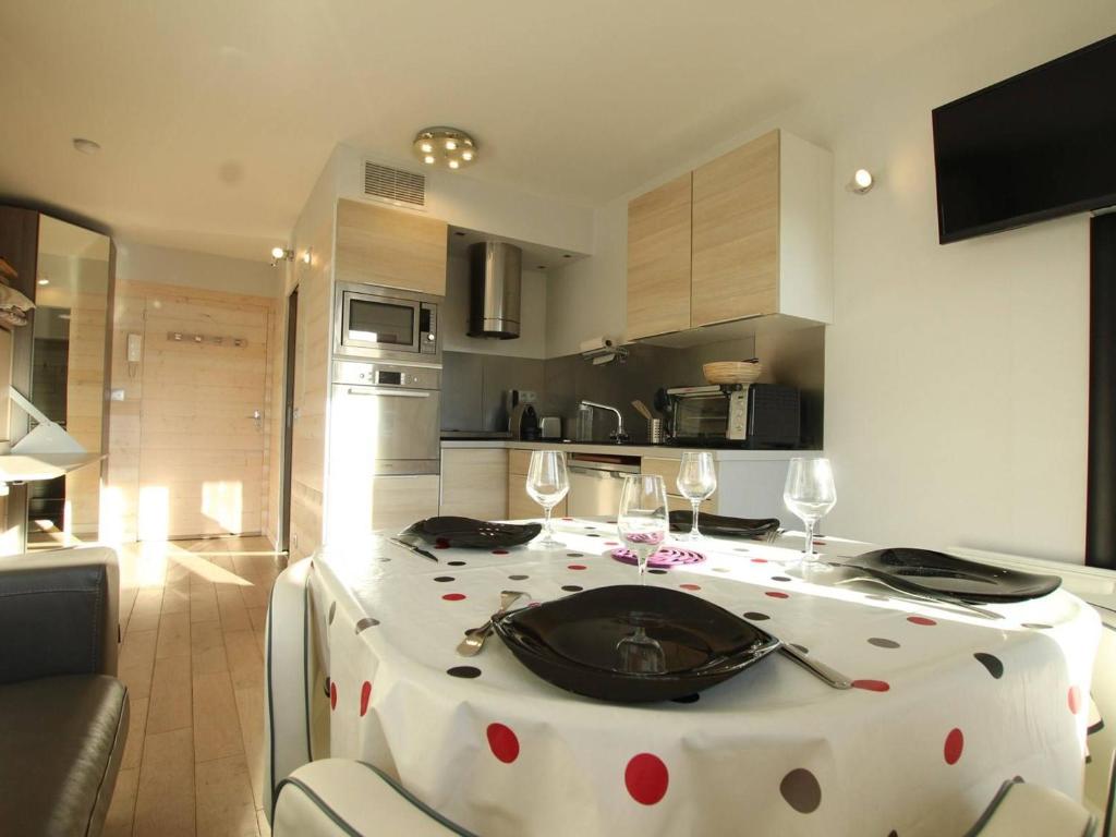 a kitchen with a table with a polka dot table cloth at Studio rénové 4 pers à Saint-Chaffrey avec balcon, classé 3 étoiles - FR-1-330E-117 in Saint-Chaffrey