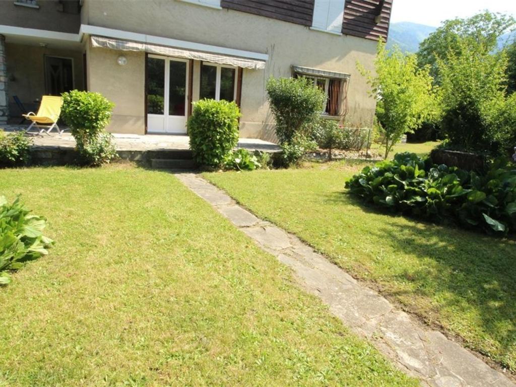 einen Hof mit einem Haus und einem Rasen mit Bürgersteig in der Unterkunft Appartement Bagnères-de-Luchon, 3 pièces, 6 personnes - FR-1-313-177 in Luchon
