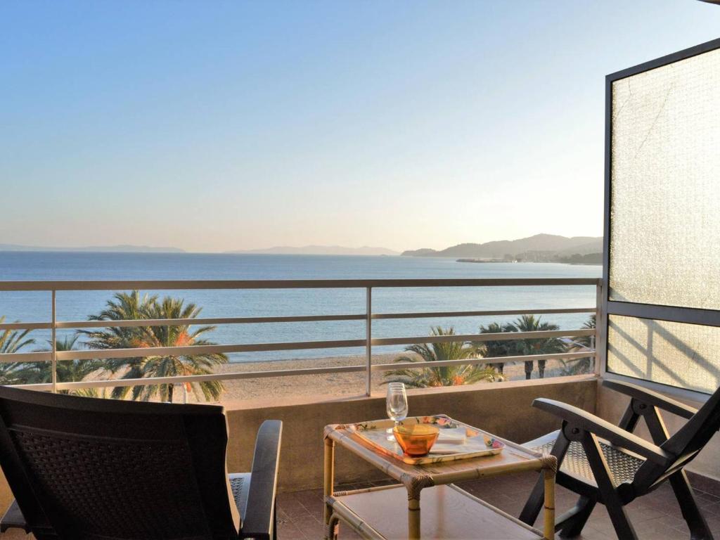 une table et des chaises sur un balcon avec vue sur l'océan dans l'établissement Appartement T2 climatisé, terrasse, plage à 3 couchages - FR-1-251-379, au Lavandou