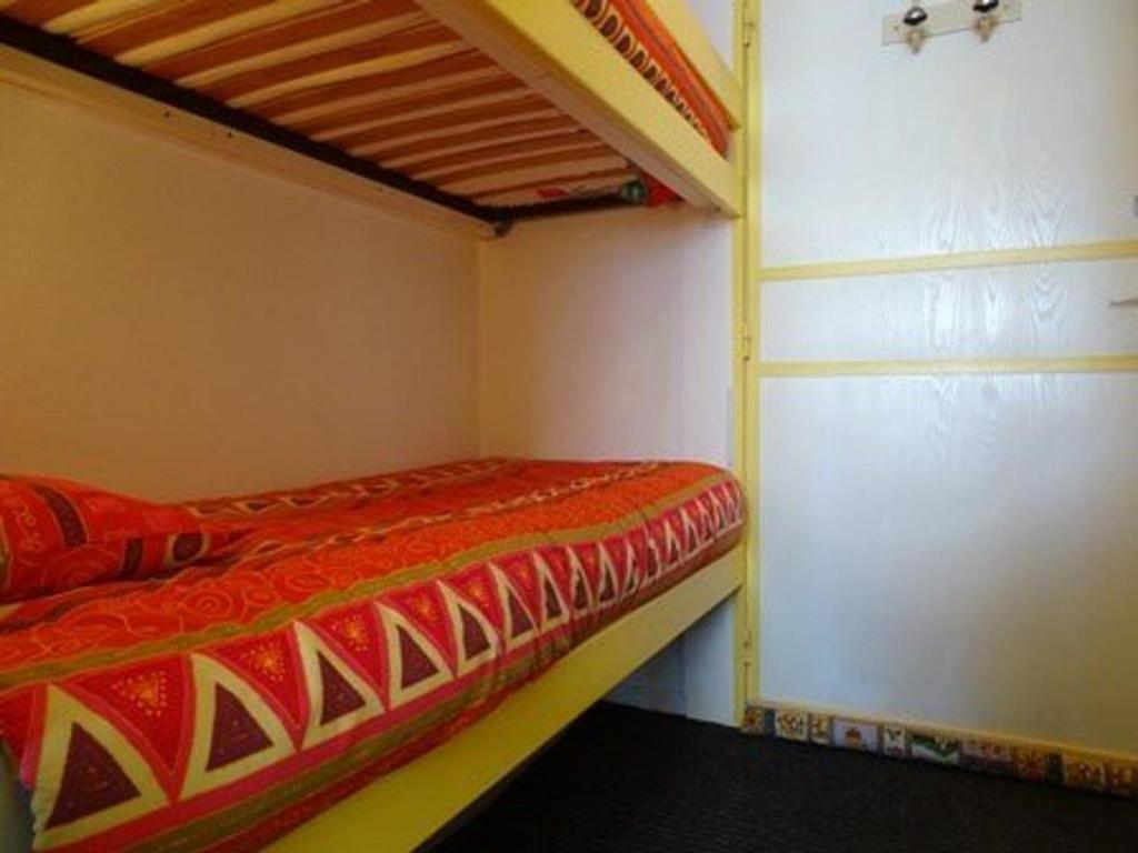 une chambre avec un lit superposé avec un couvre-lit rouge et jaune dans l'établissement Studio 4 pers. au pied des pistes avec balcon - Arette - FR-1-602-7, à Arette