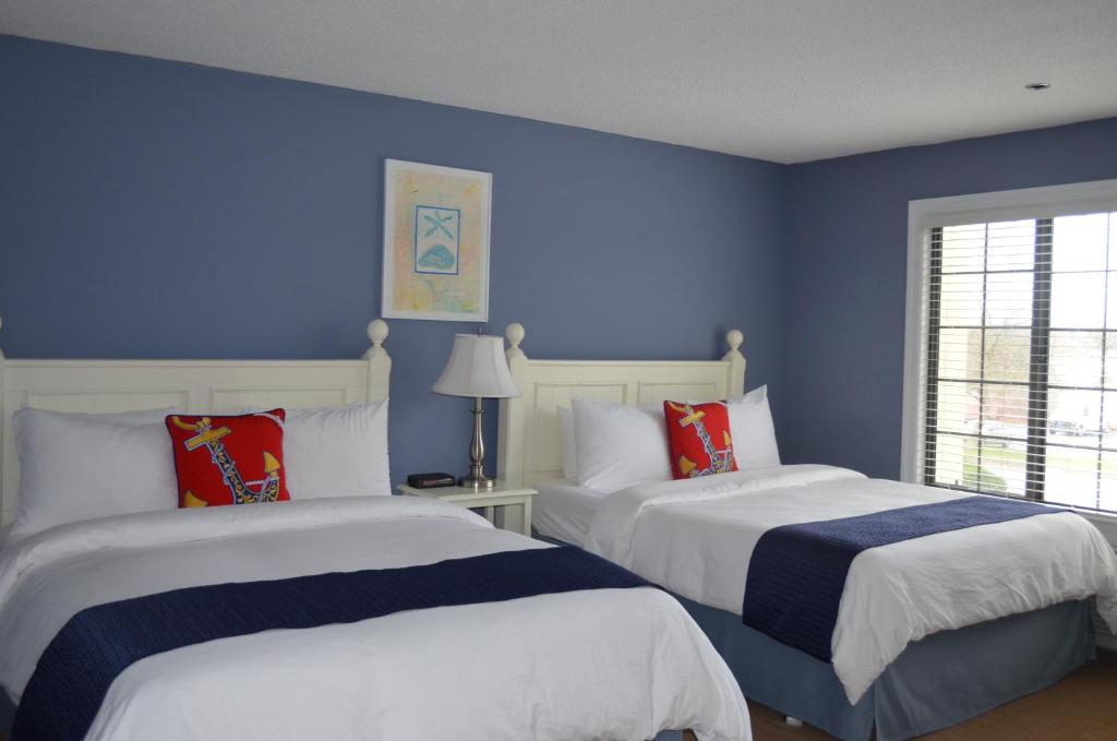 two beds in a bedroom with blue walls at Southampton Inn in Southampton