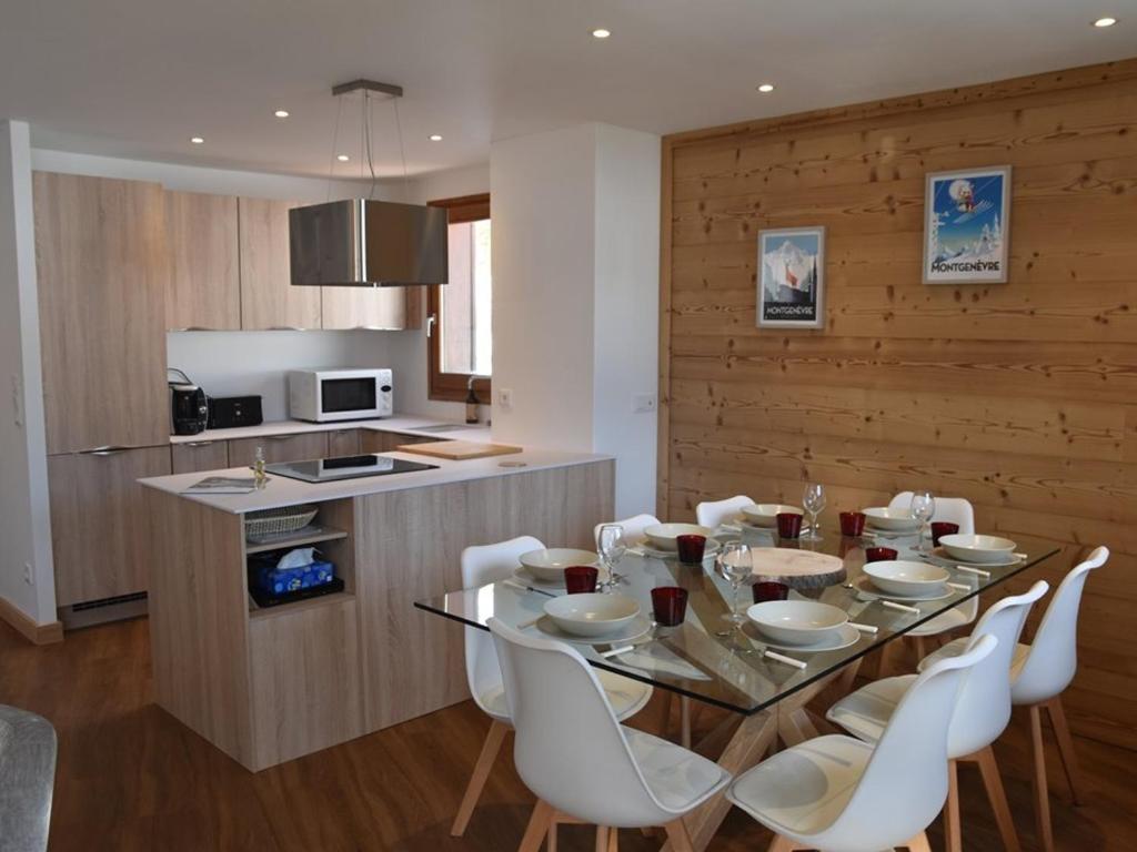 une salle à manger avec une table en verre et des chaises blanches dans l'établissement Duplex rénové 3 chambres avec wi-fi, garage, balcon sud, proche pistes à Montgenèvre - FR-1-266-162, à Montgenèvre