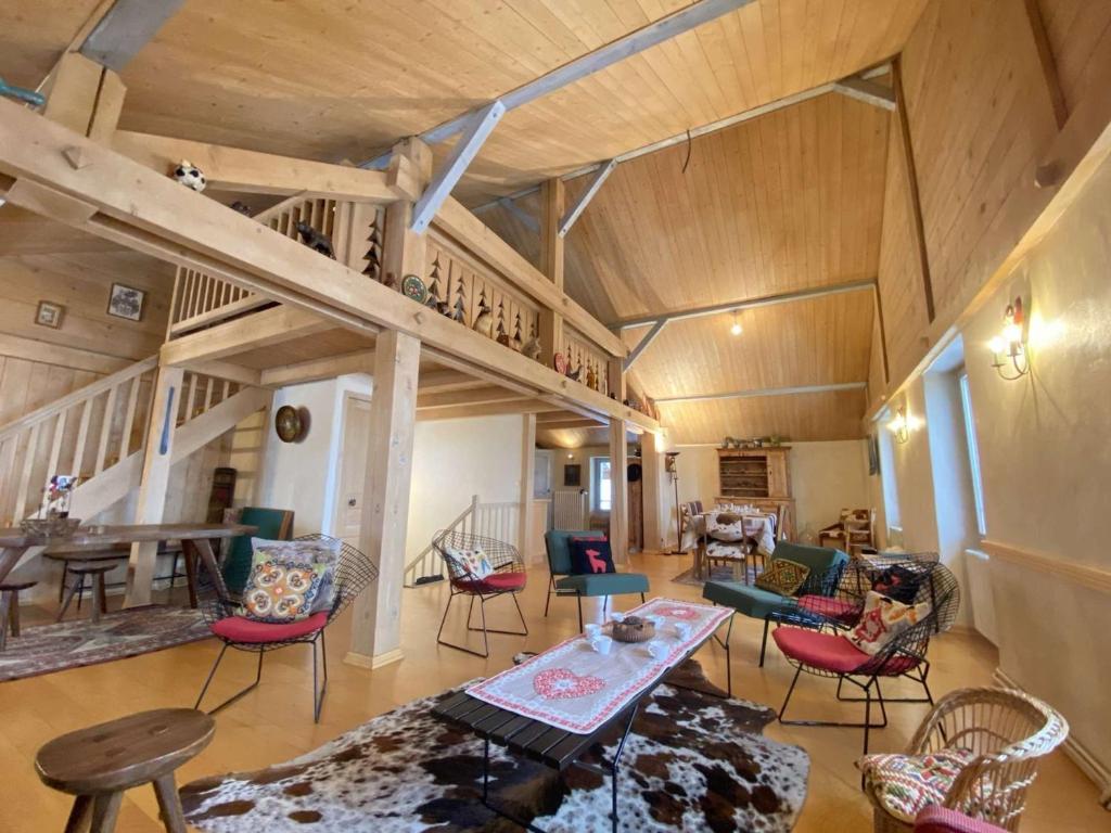 uma grande sala de estar com cadeiras e uma mesa em Appartement Praz-sur-Arly, 5 pièces, 8 personnes - FR-1-603-7 em Praz-sur-Arly