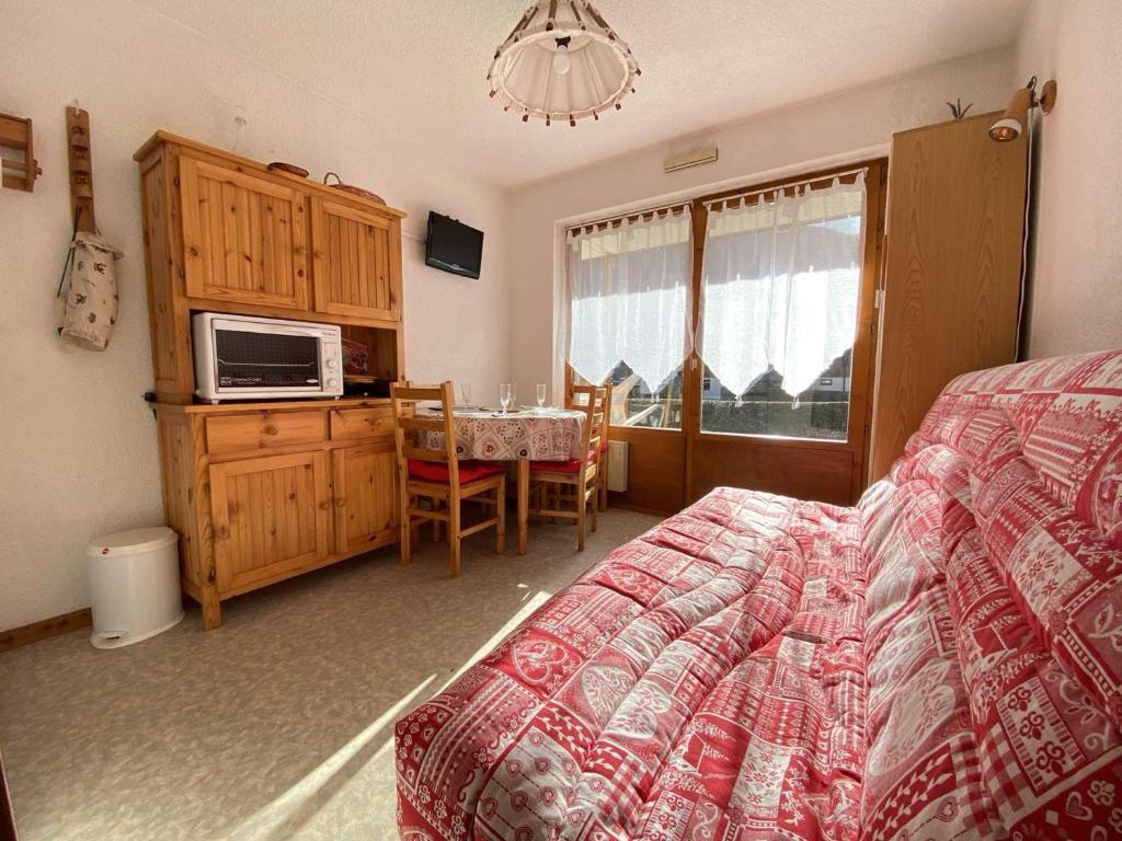 a bedroom with a bed and a table and a microwave at Appartement Praz-sur-Arly, 1 pièce, 4 personnes - FR-1-603-28 in Praz-sur-Arly