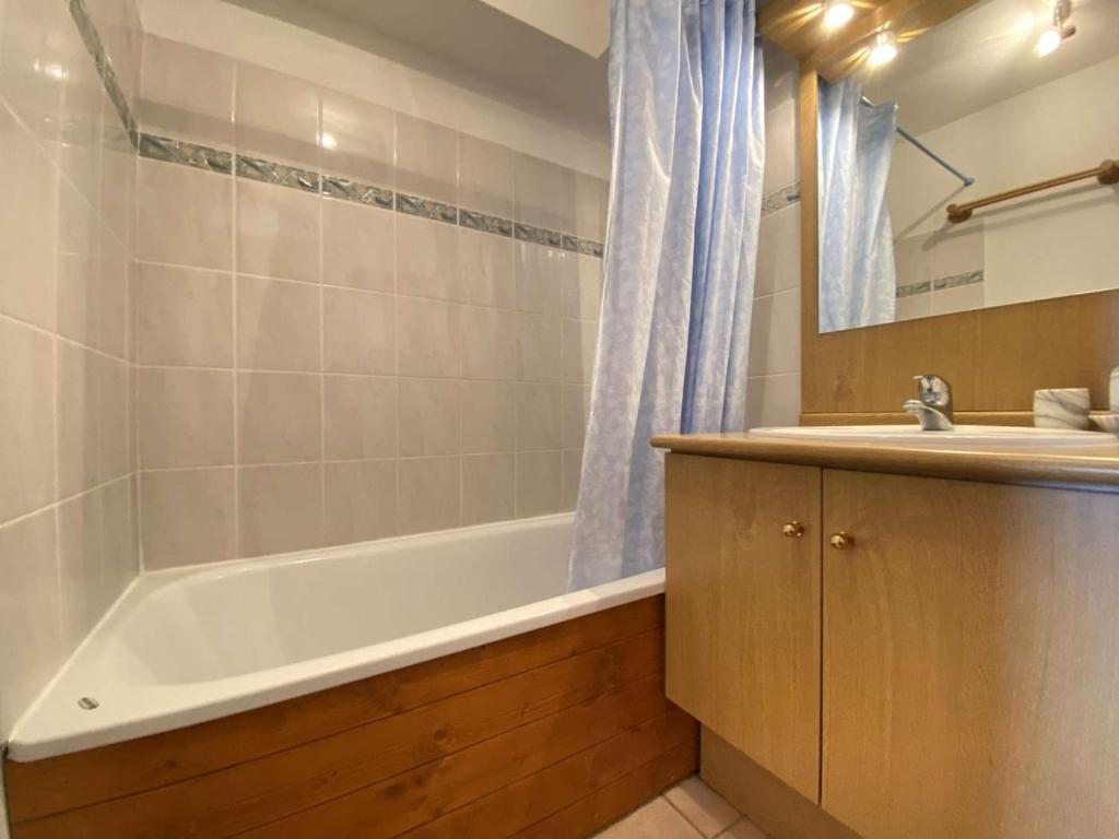 a bathroom with a tub and a sink and a bath tub at Appartement Praz-sur-Arly, 3 pièces, 6 personnes - FR-1-603-16 in Praz-sur-Arly