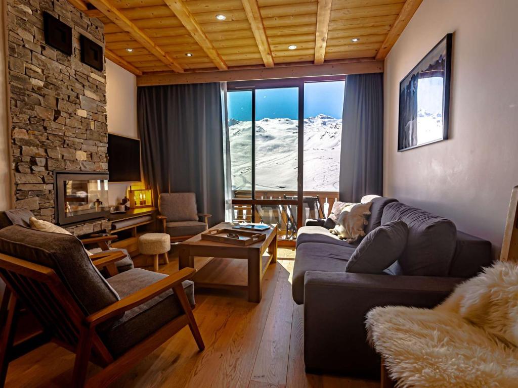 a living room with a dog laying on a couch at Appt 10 pers rénové, calme, balcon sud, cheminée, Wi-Fi, proche pistes - FR-1-545-14 in Val Thorens