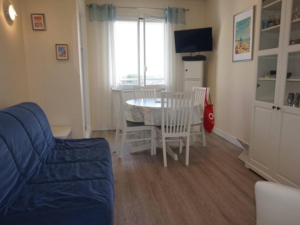 un salon avec une table, des chaises et une télévision dans l'établissement Appartement à Cabourg proche plage et casino, 4 personnes, parking privatif - FR-1-465-61, à Cabourg