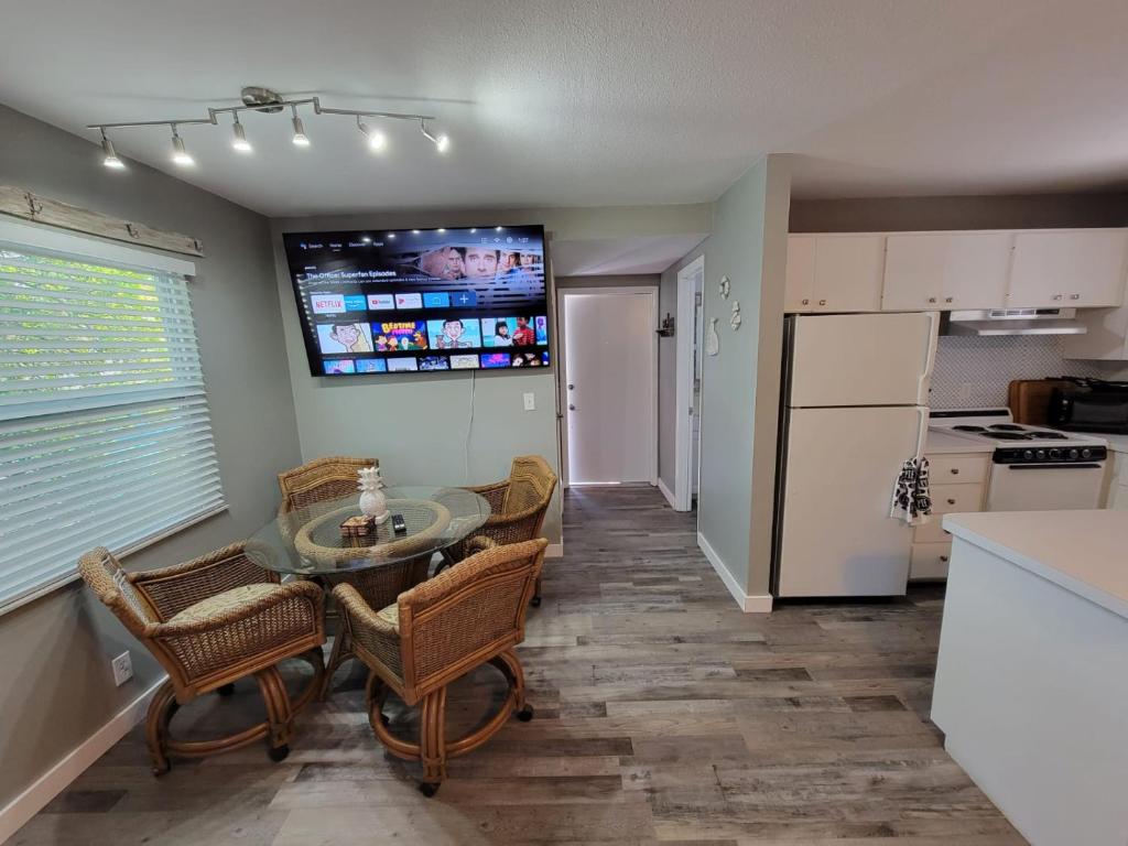 uma cozinha com mesa e cadeiras e uma televisão em Walk To Siesta Beach, Restaurants, Shopping & More! em Sarasota