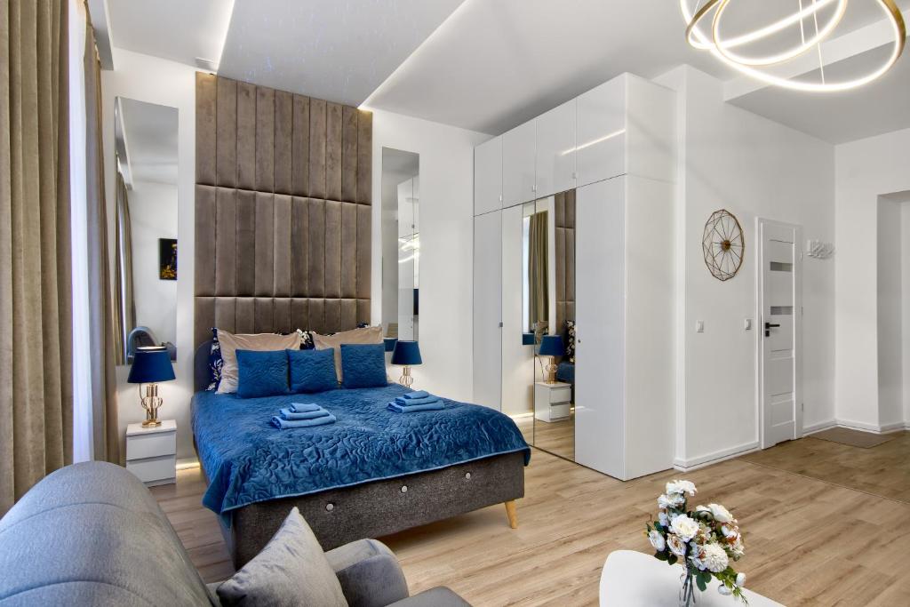a bedroom with a blue bed and a couch at Silver Shine jacuzzi in Kraków
