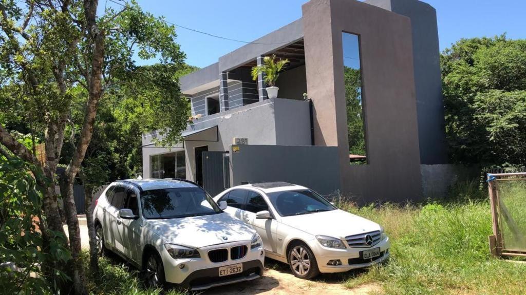 dos autos estacionados frente a una casa en Casa na Praia Norte da ilha, en Florianópolis