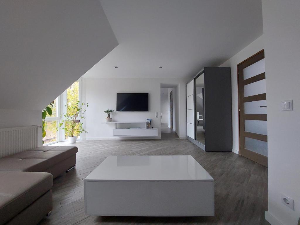 uma sala de estar com um sofá e uma mesa de centro em Bagoly Apartman em Eger