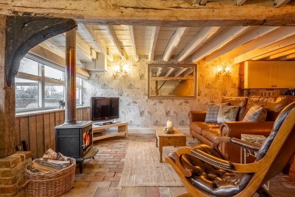 a living room with a couch and a wood stove at The Dairy at Green Valley Farm in Laxfield