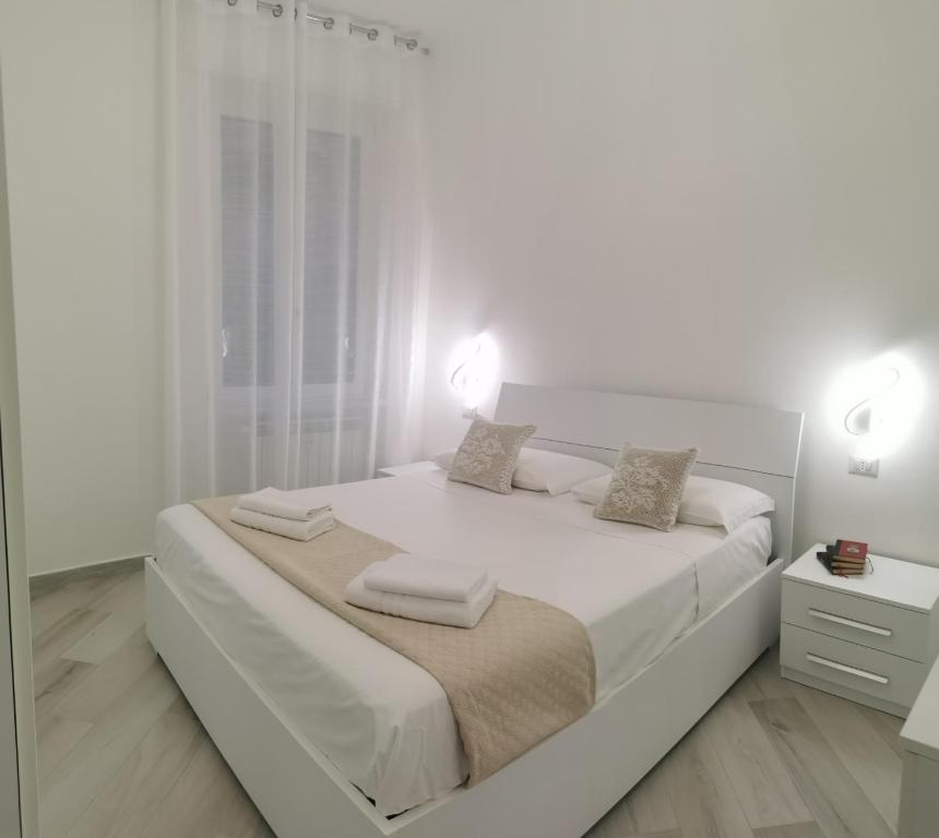 a white bedroom with a large bed with two pillows at Residenze Niguarda E in Milan