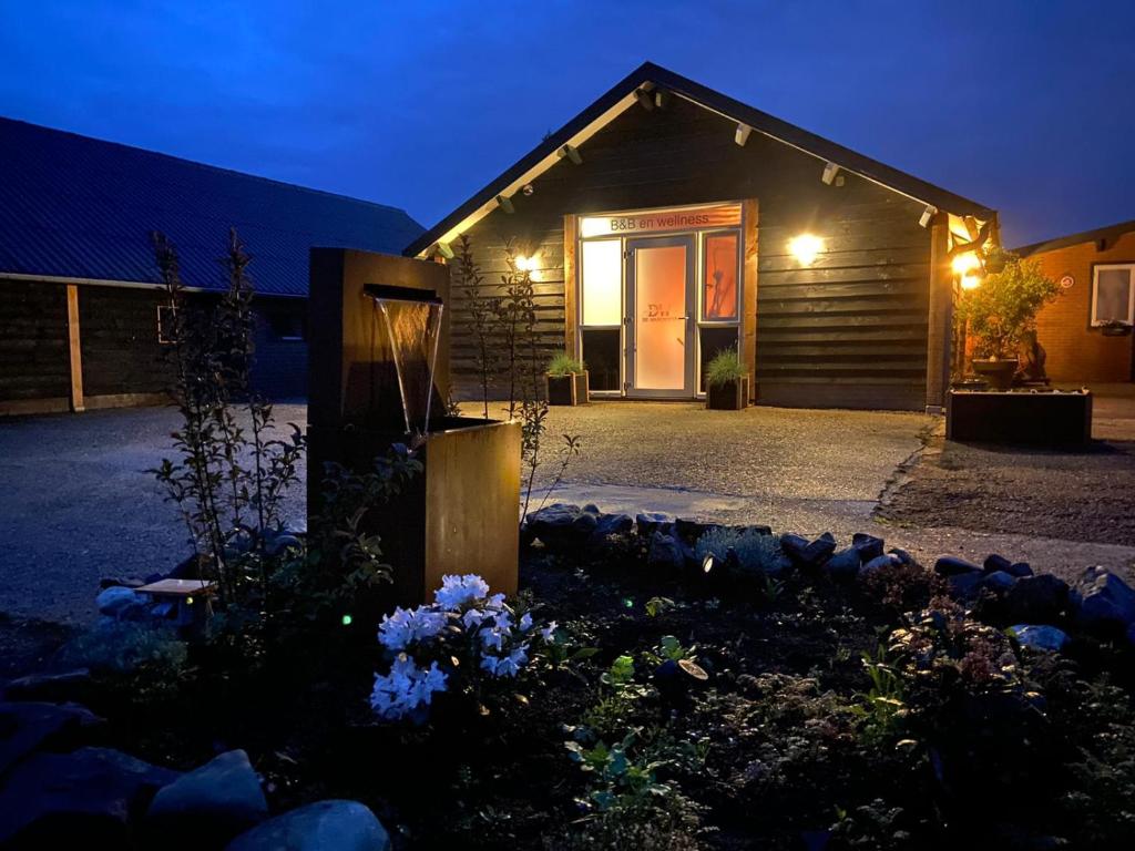 ein Haus mit einer beleuchteten Tür in der Nacht in der Unterkunft B&B en Wellness de Waalhoeve in Angerlo