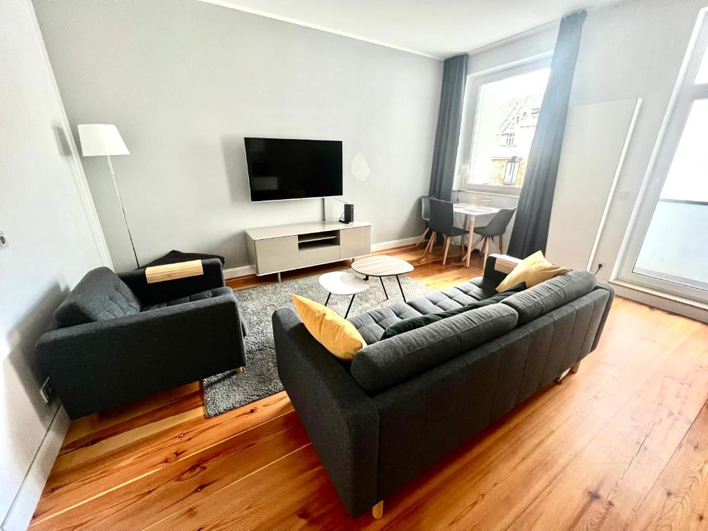 ein Wohnzimmer mit einem Sofa und einem TV in der Unterkunft Cityapartments Düsseldorf - Stresemannstraße in Düsseldorf
