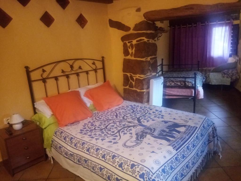 1 dormitorio con cama y pared de piedra en LA MANDUCA, en Teruel