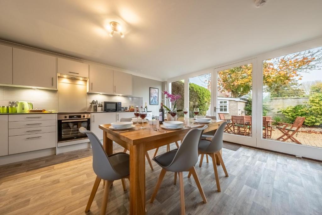 een keuken en eetkamer met een houten tafel en stoelen bij Maltings Lodge in Chelsworth