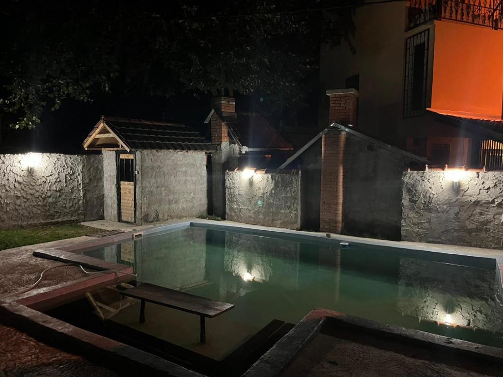 una piscina notturna con una panchina accanto di Rock House a Novi Sad