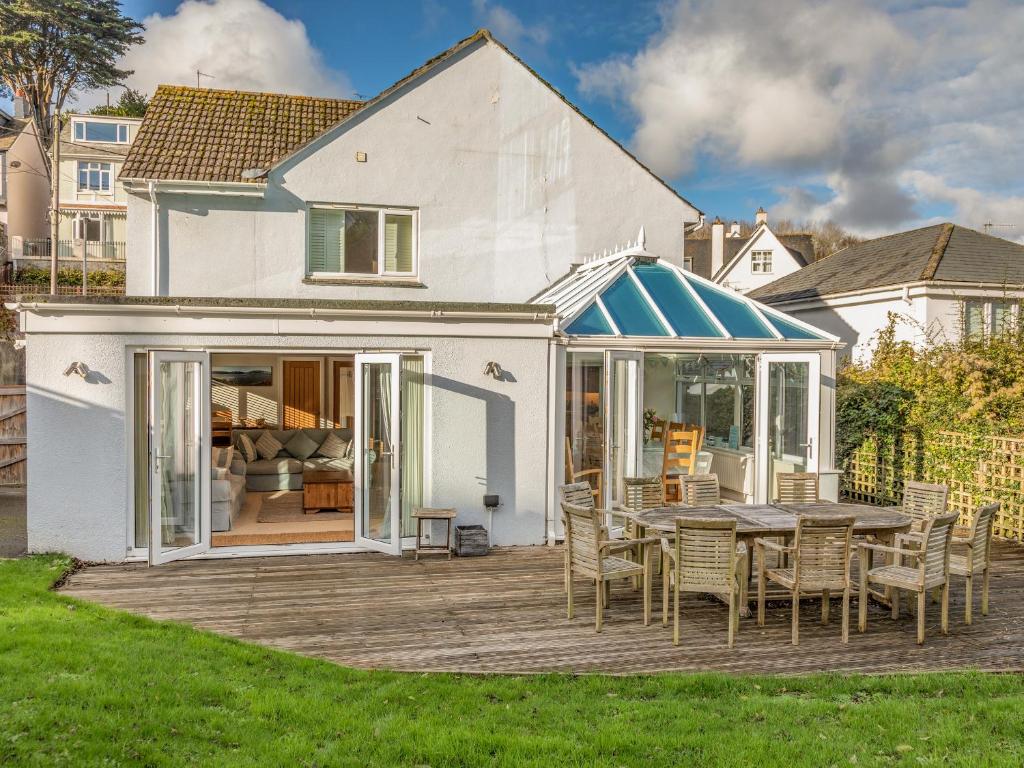 a patio with a table and chairs on a deck at Welsummer in Salcombe