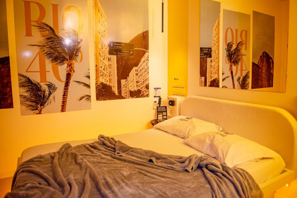 Bett in einem Zimmer mit Plakaten an der Wand in der Unterkunft Motel Itapuã III Fx Rosário do Sul in Santa Maria