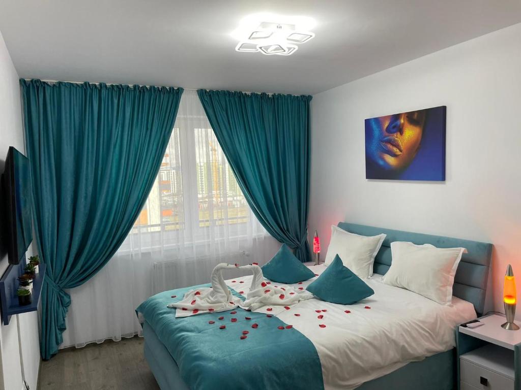 a bedroom with a bed with blue curtains at Apartamente Lux SYA Residence in Braşov