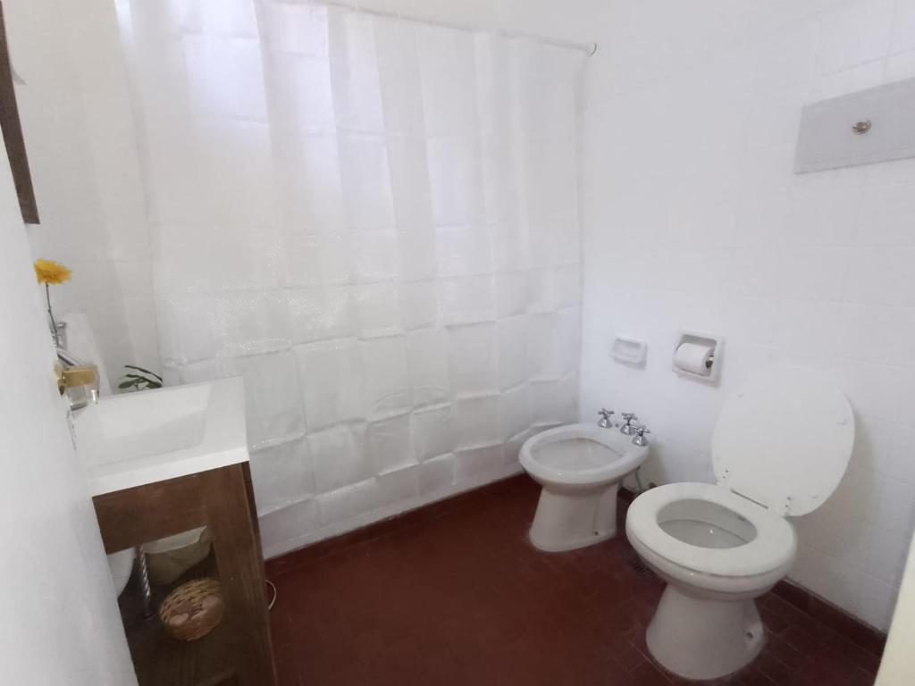 a white bathroom with a toilet and a sink at Aristobulo in Buenos Aires