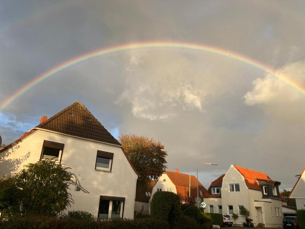 um arco-íris no céu acima de algumas casas em Casa Bianca em Fehmarn