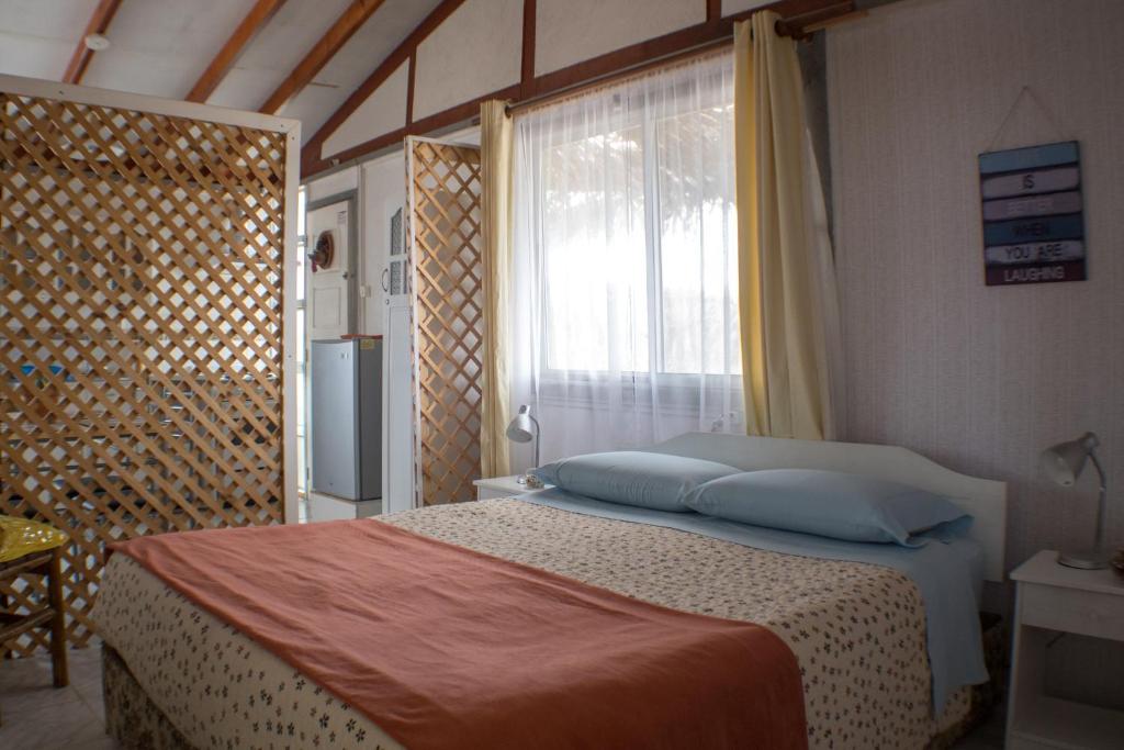 1 dormitorio con 1 cama grande y ventana en Cabañas Ecologicas Alto Cañizares, en Bahía Inglesa