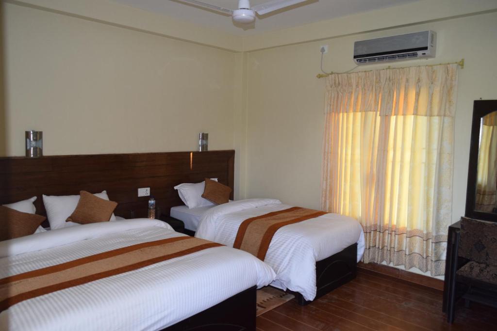 Postel nebo postele na pokoji v ubytování Chitwan Village Resort