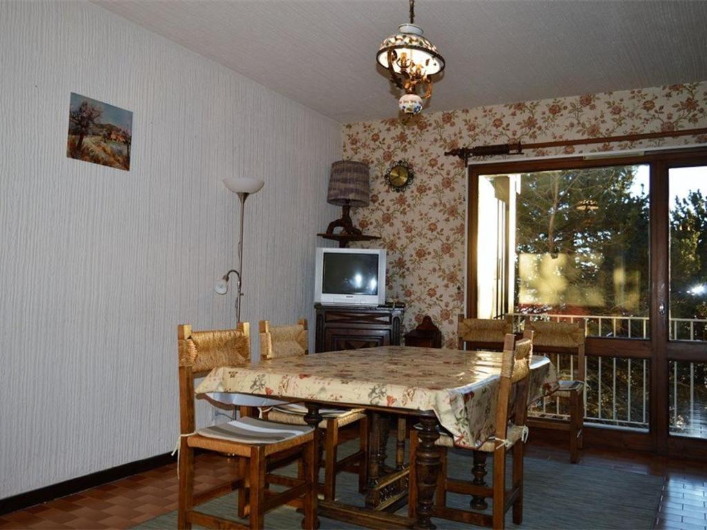 a dining room with a table and chairs and a television at Appartement Font-Romeu-Odeillo-Via, 3 pièces, 6 personnes - FR-1-580-32 in Font-Romeu-Odeillo-Via