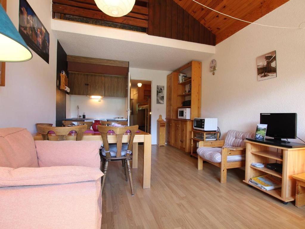 ein Wohnzimmer mit einem Sofa und einem Tisch mit Stühlen in der Unterkunft Appartement Vallouise, 1 pièce, 4 personnes - FR-1-330G-126 in Puy-Saint-Vincent