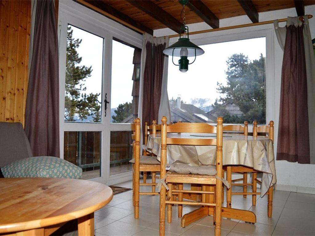 a dining room with a table and chairs and a window at Chalet Bolquère-Pyrénées 2000, 3 pièces, 7 personnes - FR-1-592-27 in Bolquere Pyrenees 2000