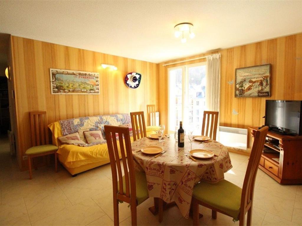 a living room with a table and a couch at Appart. central 6/7 pers. à Bagnères-de-Luchon avec parking et animaux admis - FR-1-313-171 in Luchon