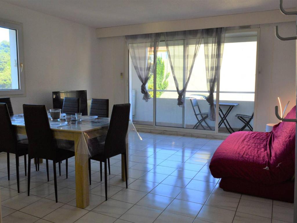 a dining room with a table and chairs and a couch at Appartement Collioure, 3 pièces, 6 personnes - FR-1-225-705 in Collioure
