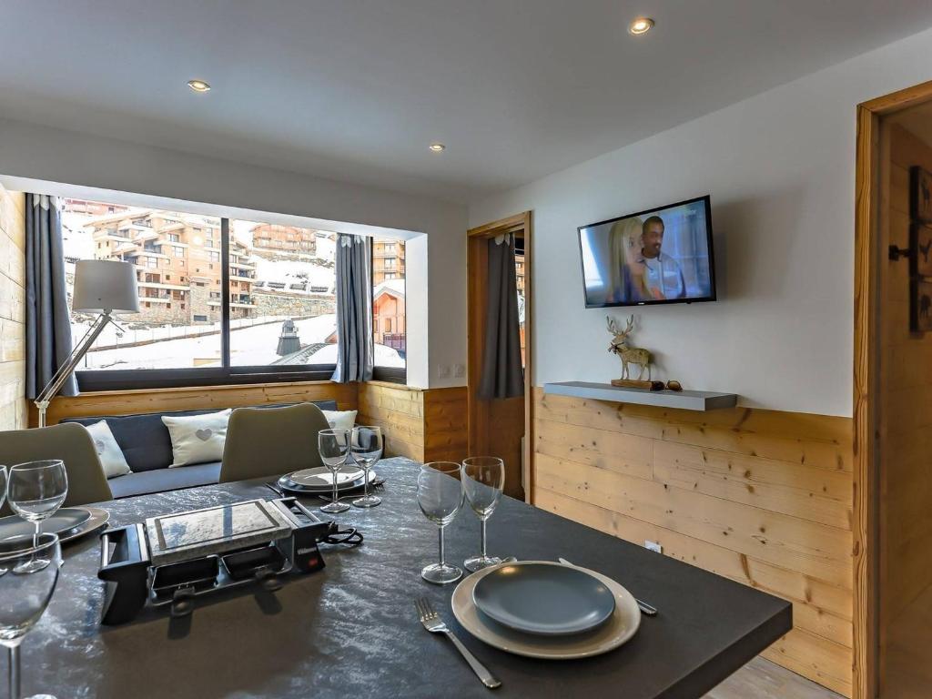 a dining room with a table with wine glasses on it at appartement 4 personnes, très cosy et fonctionnel, 2 chambres séparées, vue montagne, exposé nord, départ ski aux pieds - FR-1-545-13 in Val Thorens