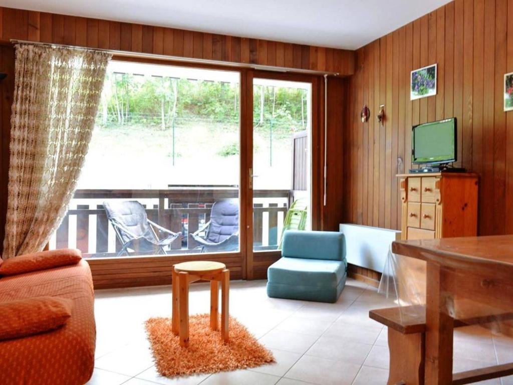 sala de estar con sofá y TV en Studio Le Grand-Bornand, 1 pièce, 4 personnes - FR-1-241-228 en Le Grand-Bornand