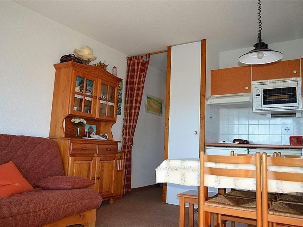 ein Wohnzimmer mit einem Sofa und einer Küche in der Unterkunft Appartement Font-Romeu-Odeillo-Via, 2 pièces, 6 personnes - FR-1-580-30 in Font Romeu Odeillo Via