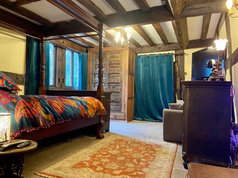 een slaapkamer met een bed in een kamer met blauwe gordijnen bij The Vauld, 2 bedroom suite with Bed and Breakfast in Bodenham