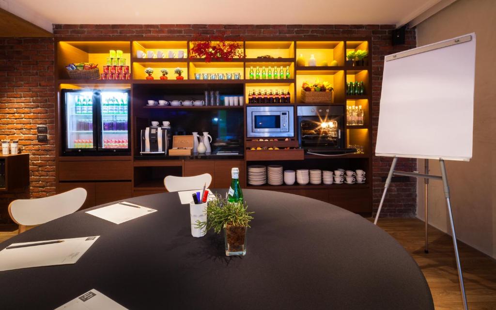 A round meeting table sits in a warmly lit conference room with a whiteboard.