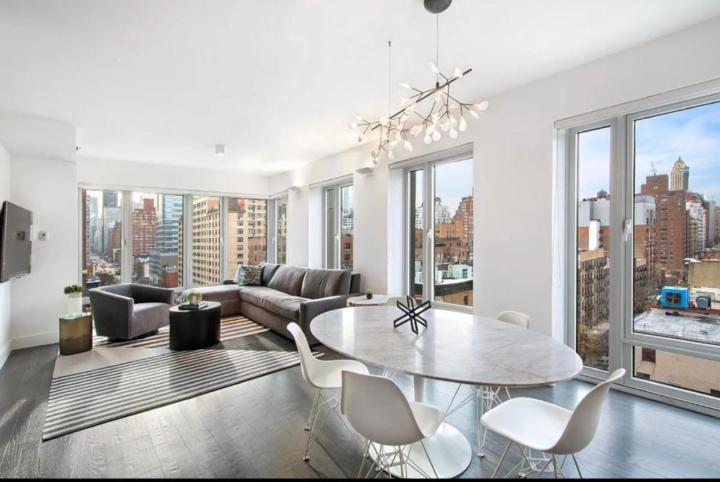 a living room with a table and chairs and a couch at Lovely 3 Bedroom Condo near Central Park in New York