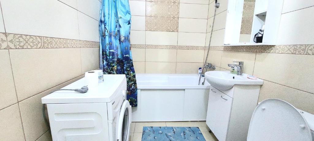 a bathroom with a sink and a toilet and a shower curtain at Ботанический сад Астана in Taldykolʼ