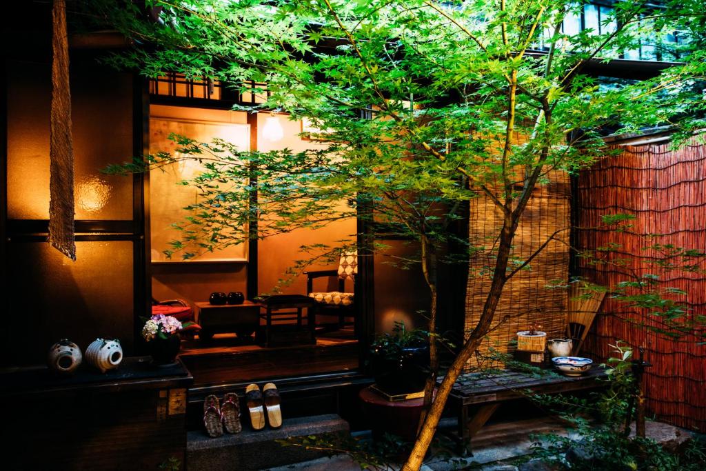 una sala de estar con un árbol y una mesa en Tsukito en Kioto