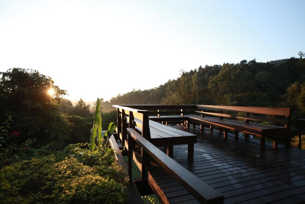a group of benches sitting on a wooden deck at Vanilla hill (hill lodge) in Ban Muang Ha
