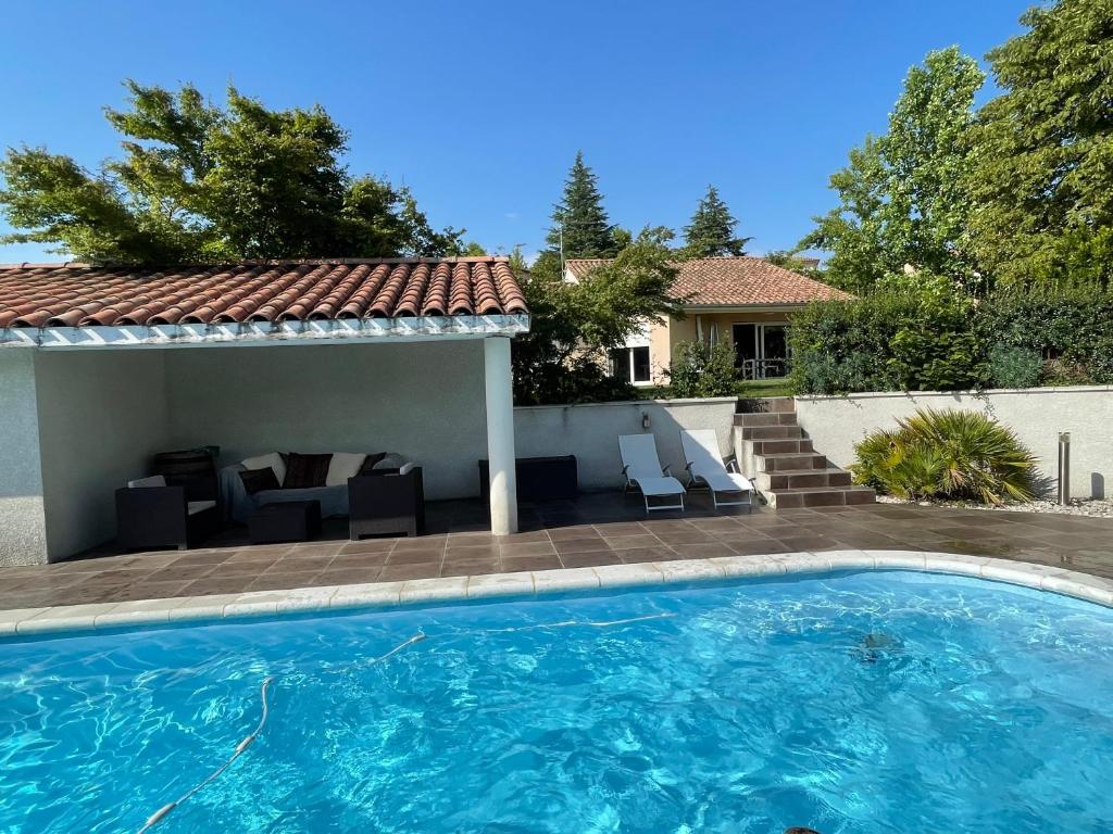 a swimming pool in front of a house at Très belle villa avec piscine dans la Drôme in Romans-sur-Isère