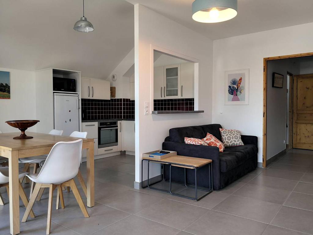 a living room with a couch and a table at Appartement fonctionnel avec balcon, à 10 min du centre, parking gratuit, idéal pour 5 personnes - FR-1-548-3 in Villard-de-Lans
