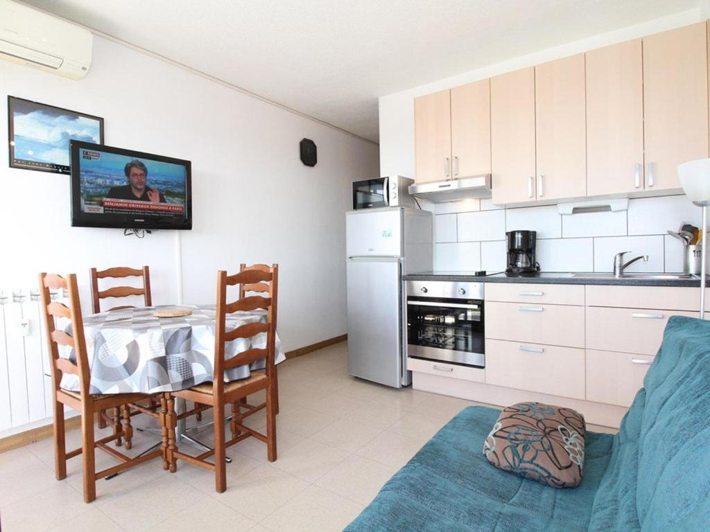 une cuisine avec une table et des chaises dans une pièce dans l'établissement T1 à Balaruc-les-Bains avec Clim et Wifi - FR-1-553-39, à Balaruc-les-Bains