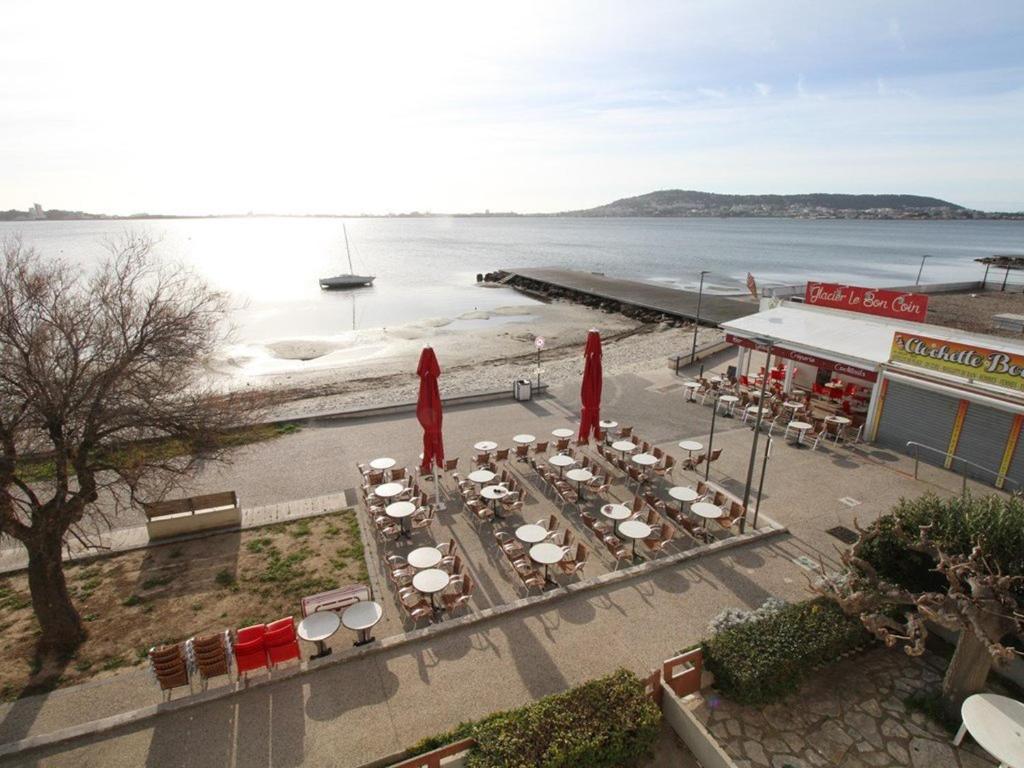 un groupe de tables et de chaises à côté de l'eau dans l'établissement Studio climatisé avec WIFI à Balaruc-les-Bains - FR-1-553-23, à Balaruc-les-Bains
