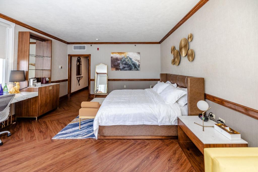 1 dormitorio con 1 cama grande y baño en Chateau Merrimack Hotel & Spa en Tyngsboro